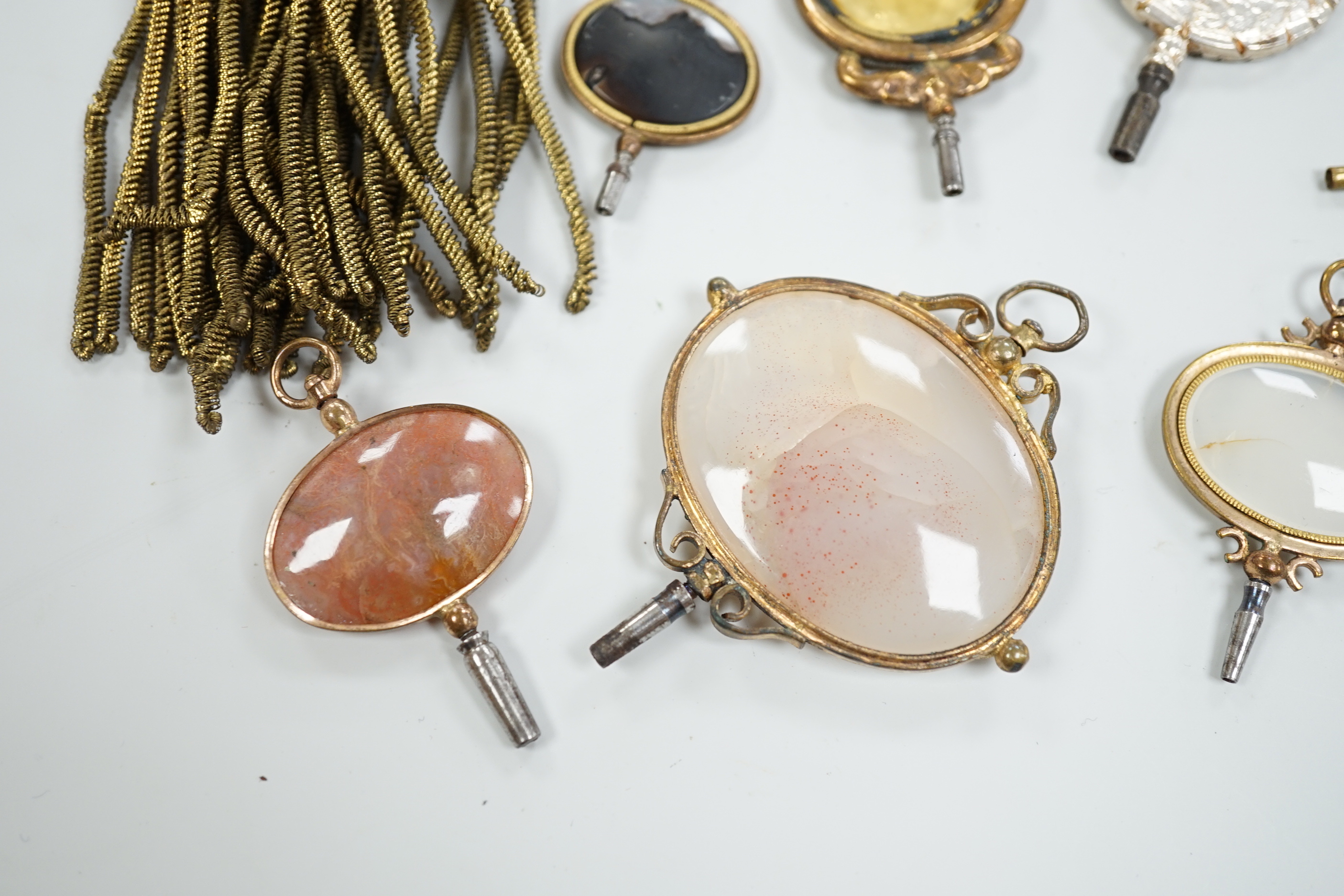 Ten assorted mainly 19th century base or yellow metal oval and gem set large watch keys, including agate and citrine paste and one set with French medallion, largest 69mm.